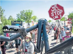  ?? ALEX KORMANN THE ASSOCIATED PRESS ?? Protesters carry a makeshift "black snake" resembling a pipeline last week in Clearwater County, Minn. Nearly 250 people were arrested during the protests against Enbridge’s Line 3 project.
