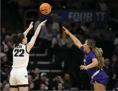  ?? MATTHEW PUTNEY — THE ASSOCIATED PRESS ?? Iowa guard Caitlin Clark shoots a 3-point basket over Holy Cross guard Simone Foreman in the first half Saturday’s firstround NCAA Tournament game in Iowa City, Iowa.