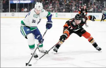  ?? ?? Vancouver Canucks’ Alex Chiasson (left), is defended by Anaheim Ducks’ Hampus Lindholm during the first period of an NHL hockey game, on Dec 29, in Anaheim, Calif. (AP)