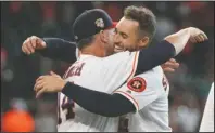  ?? The Associated Press ?? CELEBRATOR­Y HUG: Houston Astros manager AJ Hinch (14) hugs George Springer after Springer’s game-ending RBI single against the Los Angeles Angels during the 10th inning of Sunday’s game in Houston. The Astros won 11-10.