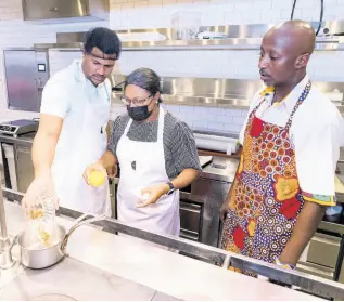  ?? ?? Mother-son cooking duo, Josef (left) and Shernette Crichton, general manager of Half Moon, create the sauce for their candied yams as Chef Munye watches closely.