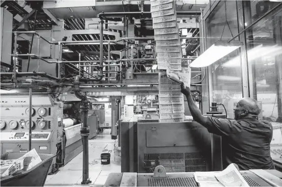  ?? Michael Ciaglo photos / Houston Chronicle ?? Press operator Timothy Trahan checks the color on pages coming off the press at the new Houston Chronicle building. The presses had already been relocated to the facility for several years before the newsroom and other department­s moved in early 2016.