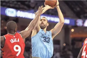  ??  ?? Marc Gasol shoots over Raptors defender Serge Ibaka during the Grizzlies' loss Tuesday. JOE RONDONE/THE COMMERCIAL APPEAL