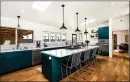  ??  ?? The spacious kitchen tacks on teal cabinetry topped by marble counter tops.