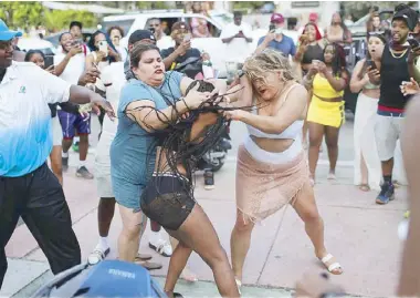  ?? AFP ?? Women fight on the street near Ocean Drive in Miami Beach, Florida on Friday. City officials are concerned with large spring break crowds as the coronaviru­s pandemic continues.