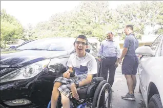  ?? CHAD RHYM PHOTOS / CHAD.RHYM@ AJC.COM ?? Alan Youssef, who has cerebral palsy, looks around the new family vehicle. The Kurdish family fled Syria as refugees four years ago after Islamic State fighters invaded their town and started executing people.