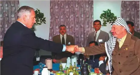  ?? AP ?? Benjamin Netanyahu and then Palestinia­n National Authority president Yasser Arafat after signing an agreement on the partial withdrawal of Israeli occupation troops from the West Bank during a meeting in Gaza on January 15, 1997.