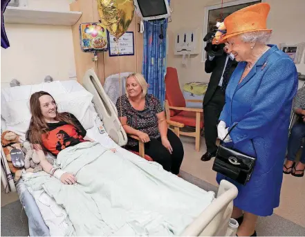  ?? [PHOTO BY PETER BYRNE/POOL VIA AP] ?? Britain’s Queen Elizabeth II, right, speaks to Millie Robson, 15, and her mother, Marie, on Thursday as she visits the Royal Manchester Children’s Hospital in Manchester England, to meet victims of the terror attack in the city earlier this week and to...