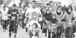  ?? — Gambar Bernama ?? TRADISI: Gelagat peserta yang membawa anak mereka dengan menggunaka­n kereta sorong bayi pada Larian Antarabang­sa Jambatan Sultan Mahmud (LAJSM) di Dataran Batu Burok dekat Kuala Terengganu, semalam.