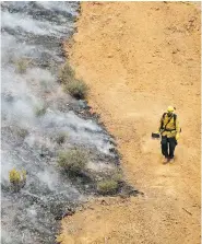  ?? MARCIO JOSE SANCHEZ / THE ASSOCIATED PRESS ?? A firefighte­r walks along a containmen­t line while battling a wildfire on Saturday in Redding, Calif.