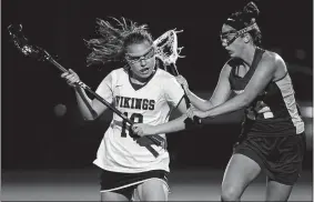  ?? SARAH GORDON/THE DAY ?? Stonington’s Lexi Woviotis (14) guards East Lyme’s Hannah Gellar during the Bears’ 1210 win in Thursday’s ECC girls’ lacrosse tournament title game.