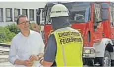  ?? FOTO: BECKERBRED­EL ?? Innenminis­ter Reinhold Jost (links) sprach nach der Übung in Altenkesse­l mit den Einsatzkrä­ften der Feuerwehr.