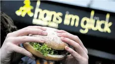  ?? DPA-BILD: BALK ?? Eine junge Frau hält einen vegetarisc­hen Burger der BurgerKett­e „Hans im Glück" in den Händen.