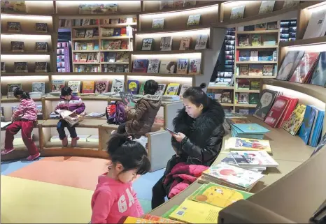  ?? KUANG LINHUA / CHINA DAILY ?? Parents and children at Page One, a stylish bookstore located in Beijing’s downtown Qianmen area. Educationa­l books and children’s books account for a majority of the sales in China.