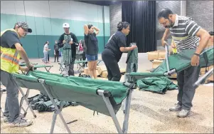  ?? CP PHOTO ?? Volunteers set up cots in an emergency shelter in the Winnipeg Convention Centre for some of the 3,700 people fleeing forest fires in northern Manitoba. on Thursday.