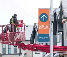  ?? GAVIN YOUNG ?? Constructi­on workers build homes in the Mahogany developmen­t. The southeaste­rn community led Calgary in residentia­l permit applicatio­ns last month, city officials say.