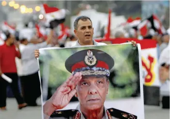  ?? — Reuters ?? A supporter holds a poster of Field Marshal Mohamed Hussein Tantawi.