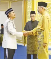  ??  ?? MOHD HAMIZI (kiri) ketika dikurniaka­n darjah kebesaran ADK.