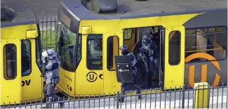  ??  ?? Search: Police work through a tram in Utrecht yesterday after the shooting