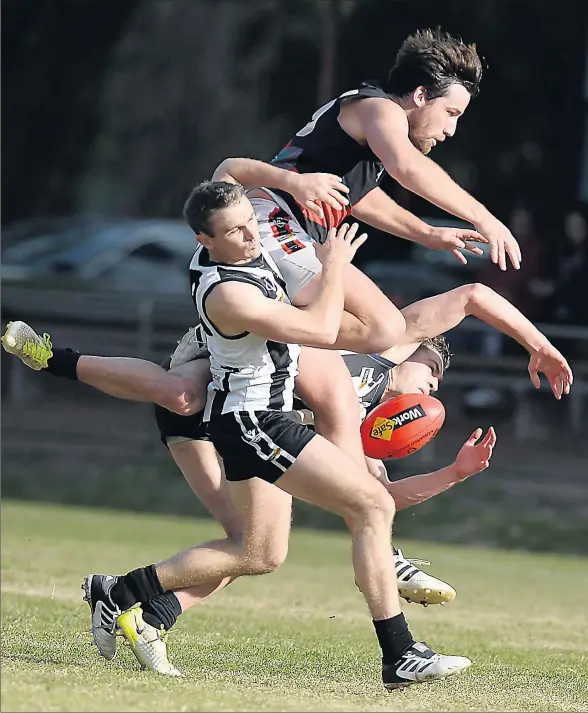 ?? Picture: Ray Sizer ?? Billy Burstin sends two Euroa players flying during Kyabram’s nail-biting seven-point win.
