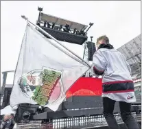  ?? CP PHOTO ?? Will Mitchell carries a Humboldt Broncos flag to the stage during a tribute to the hockey team at the Memorial Cup opening ceremony at Mosaic Stadium in Regina, Sask., Thursday