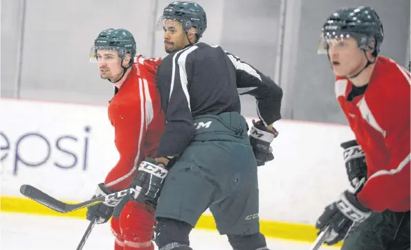  ?? JASON MALLOY/THE GUARDIAN ?? Forward Brent Andrews, left, battles for position with defenceman Austin Levi during Monday’s UPEI Panthers hockey practice.