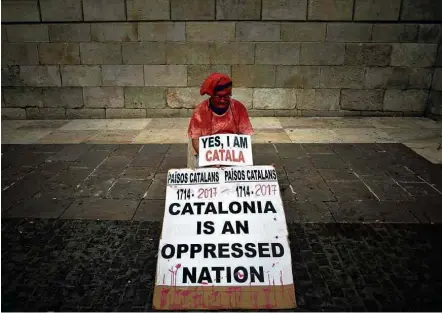  ?? Jorge Guerrero/AFP ?? Em Barcelona, partidário da independên­cia segura cartaz em que se lê ‘sim, sou catalão; a Catalunha é uma nação oprimida’