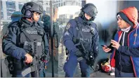  ?? AP FILE PHOTO ?? In this Dec. 29, 2016 file photo, a pedestrian asks directions from two heavily armed counterter­rorism officers stationed in Times Square in New York. New York Police Department officials say that while there are no specific or credible threats against...