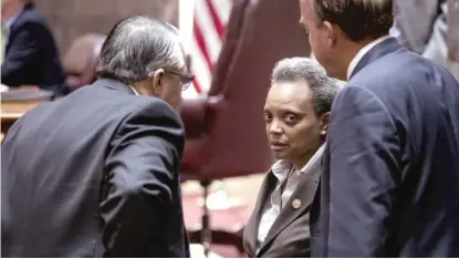  ??  ?? Mayor Lori Lightfoot speaks with Ald. Gilbert Villegas (36th) and Ald. Brendan Reilly (42nd) at a City Council meeting in December.