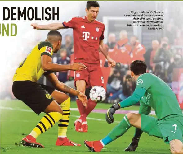  ?? REUTERS PIC ?? Bayern Munich’s Robert Lewandowsk­i (centre) scores their fifth goal against Borussia Dortmund at Allianz Arena on Saturday.