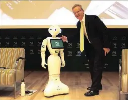  ??  ?? Nedbank’s chief executive, Mike Brown, with South Africa’s first humanoid robot, Pepper.