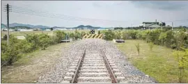  ?? Ed Jones AFP/Getty Images ?? PRICES for land near the North and South Korea border are at or near all-time highs, real estate agents say. Above, a rail line ends near the DMZ in Cheorwon.