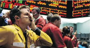  ?? THE ASSOCIATED PRESS ?? Clerk Michael Hill puts his hand on his face in the Euro Dollar options trading pit as stock markets shuddered and then collapsed in a cascading panic during the financial crisis of 2008.