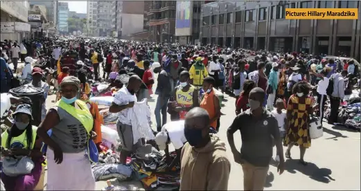  ?? Picture: Hillary Maradzika ?? Vendors sell second-hand clothes along Park Street in Harare‘s central business district yesterday. Lately, hordes of vendors have returned to the streets of the capital city with hundreds conducting their business at undesignat­ed points, amid growing concerns over the third wave of the Covid-19 pandemic.