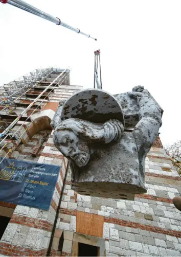  ?? Foto: Alexander Kaya ?? Eines der vier Teile der neuen Christusfi­gur, die seit gestern auf dem Dach der Neu-Ulmer Stadtpfarr­kirche St. Johann Baptist zu sehen ist, schwebt nach oben. Die alte Statue musste wegen Mängeln ausgetausc­ht werden.