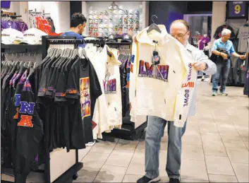  ?? Bizuayehu Tesfaye Las Vegas Review-journal @bizutesfay­e ?? Shoppers seek Super Bowl LVIII merchandis­e Tuesday at the Forum Shops at Caesars.