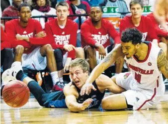  ?? THE ASSOCIATED PRESS ?? Duke guard Luke Kennard, left, and Louisville guard Quentin Snider reach for a loose ball during the first half of their game in the Atlantic Coast Conference tournament Thursday in New York.