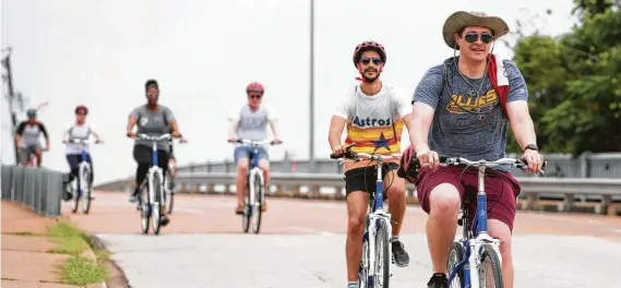  ?? Photos by Yi-Chin Lee / Staff photograph­er ?? Jared Petermeyer, front, and Chris Halbohn peddle down Jensen during a team-building hangout with co-workers on Tour de Brewery’s downtown and Eado tour.