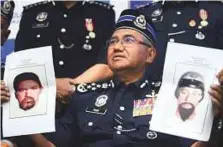  ?? AP ?? Malaysian police chief Haroun shows pictures of suspects in the killing of a Palestinia­n man during a press conference in Kuala Lumpur yesterday.