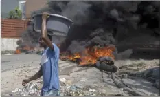  ?? AP photo ?? Burning tires block a road, set by protesters in Port-auPrince, Haiti, Monday. Workers angry about the nation’s lack of security went on strike in protest two days after 17 members of a U.S.-based missionary group were abducted by a violent gang.