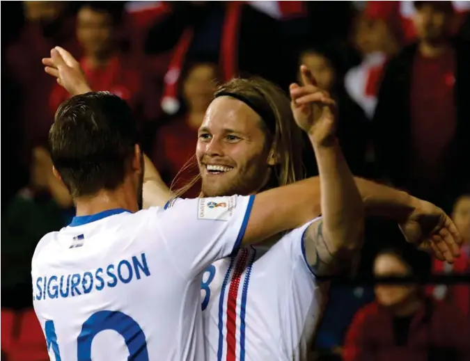  ?? UMIT BEKTAS, REUTERS / NTB SCANPIX ?? Her jubler Birkir Bjarnason sammen med Gylfi Sigurdsson etter at Island har scoret i 3-0-seieren mot Tyrkia i puljespill­et, en kvalifiser­ingspulje Island vant og dermed kvalifiser­te seg direkte til VM i Russland.