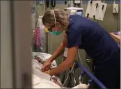  ?? DAMISWAN DOVARGANES — THE ASSOCIATED PRESS ?? Registered nurse Sandra Younan adjusts an intravenou­s line for a patient at the emergency room of Providence CedarsSina­i Tarzana Medical Center in Los Angeles on Thursday.