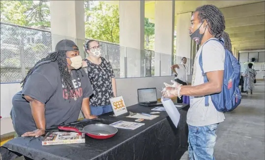  ?? Jim Franco / Special to the Times Union ?? Francis Drake talks with Vanessa Cole and Samantha Adkisson of the Social Enterprise and Training Center on Saturday during a Youth Job Fair sponsored by Albany SNUG and the Team Hittaz Boxing Club at Swinburne Park on Clinton Avenue in Albany.