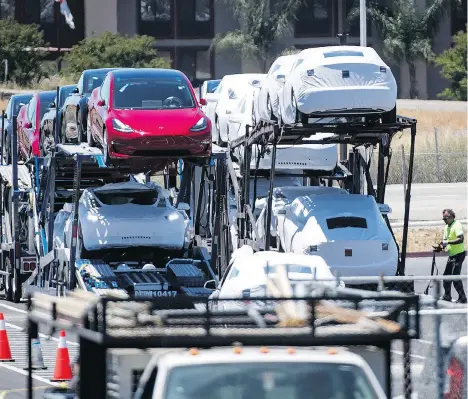  ?? DAVID PAUL MORRIS/BLOOMBERG ?? Tesla Inc. vehicles are loaded onto a truck for transport at the company’s manufactur­ing facility in Fremont, Calif., in June. Tesla is expecting to build up to 55,000 Model 3 units this quarter and has revived its goal to make 10,000 Model 3s a week...