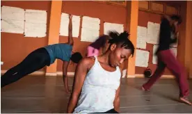  ??  ?? Carmelita Siwa, 24, from Benin, stretches with other students before rehearsal at the Ecole des Sables .