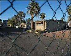  ?? PHOTOS BY MATT YORK THE ASSOCIATED PRESS ?? One of three entrances to the Periwinkle Mobile Home
Park is fenced off from the street in Phoenix in April.