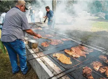  ?? J.C. Reid photos ?? In the early days, community barbecues took place in German settlement­s. Sealy still plays host to the annual Millheim Harmonie Verein community barbecue. Below: Post oak is stacked at Smitty’s in Lockhart.