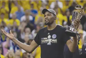  ?? The Associated Press ?? Golden State Warriors forward Kevin Durant gestures as he holds the Bill Russell NBA Finals Most Valuable Player Award after Game 5 of the NBA Finals between the Warriors and the Cleveland Cavaliers in Oakland, Calif., on June 12.