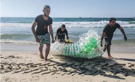  ?? Majd Mahmoud for The National ?? Mohammad Abu Zeid, left, and Mouath Abu Zeid, right, fishermen from Gaza, with their plastic boat