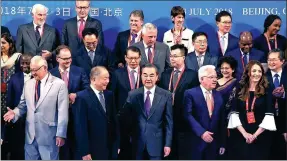  ?? ZOU HONG / CHINA DAILY ?? State Councilor and Foreign Minister Wang Yi (center) takes a group photo with foreign guests before the opening of the Forum on Belt and Road Legal Cooperatio­n in Beijing on Monday. Wang said a dispute settlement mechanism for Belt and Road will be establishe­d at an early date.